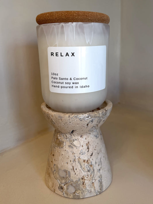 White jar Relax candle with cork lid, Palo Santo & Coconut scent, on travertine stand
