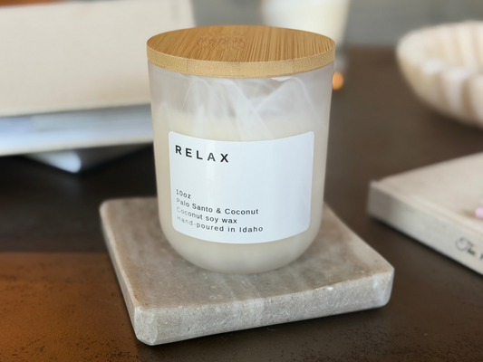 White jar Relax candle with wood lid, Palo Santo & Coconut scent, on travertine stand